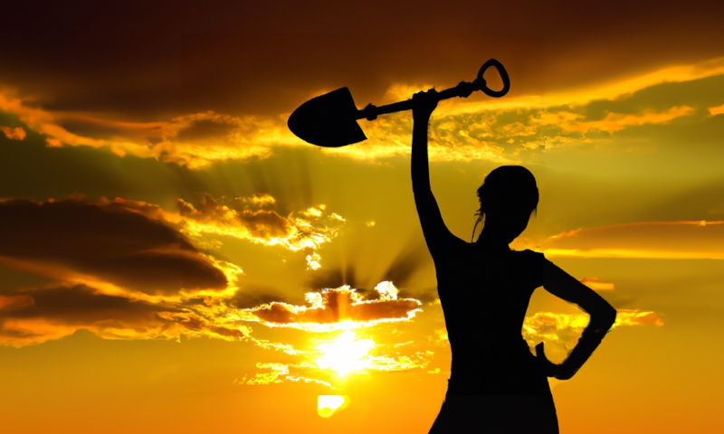 Silhouette of a woman holding a shovel that reached gold