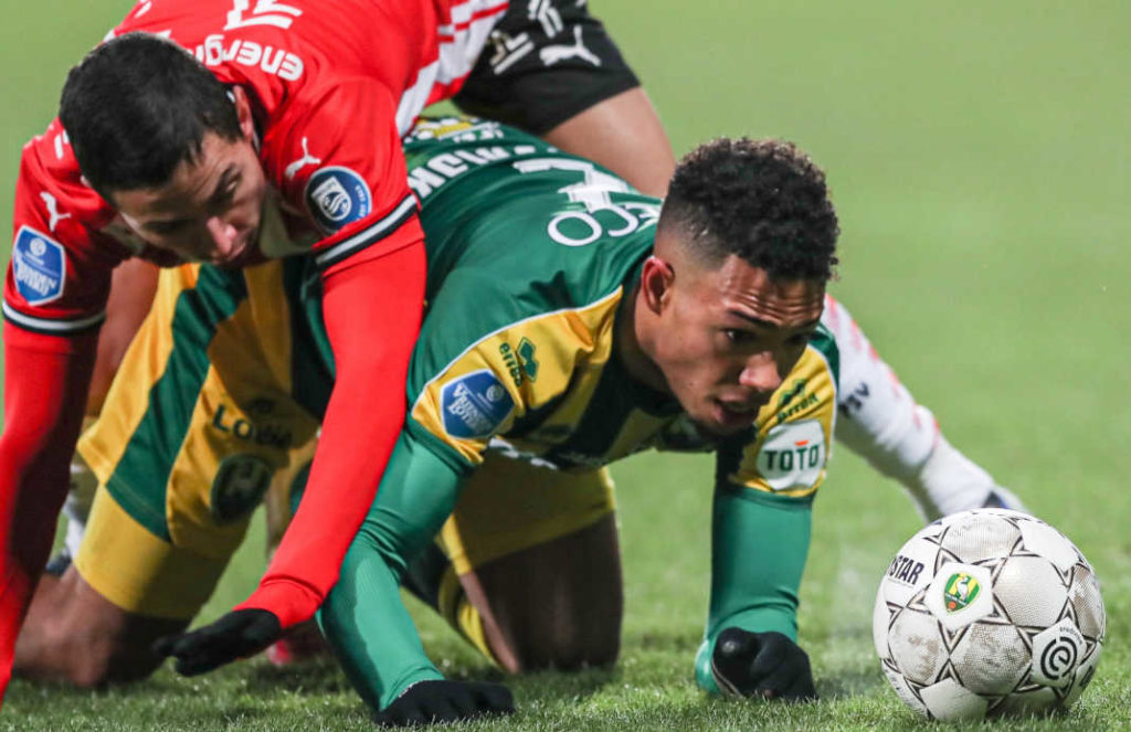 Two player of the Netherland Eredivisie fell over in a match. One player on his four watching on the ball, the other jumping over his back.