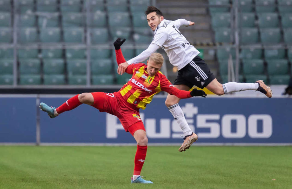 Two football players of the Poland's Ekstraklasa league having jumped for the ball. Image taken in action. Both players look like ballet dancers.