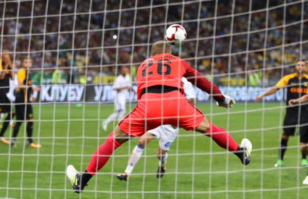 Goalkeeper David Von Ballmoos of Young Boys in action: Picture taken from the back. The goalkeeper is jumping in the air with both legs spread wide apart.